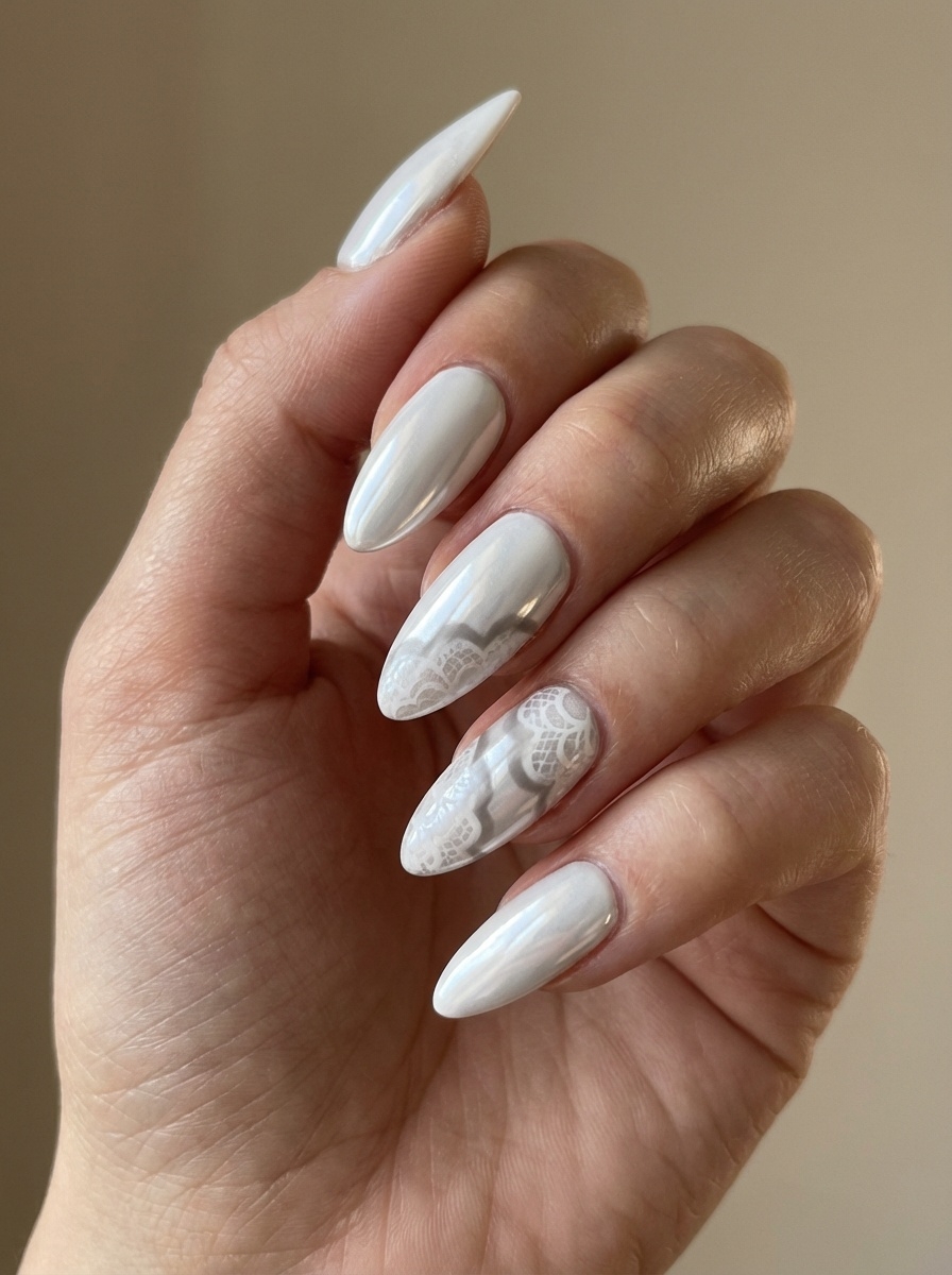 Angled view of manicured fingers displaying a white chrome nail art idea with pearl-white chrome nails and delicate lace-style patterns layered over select accent nails.