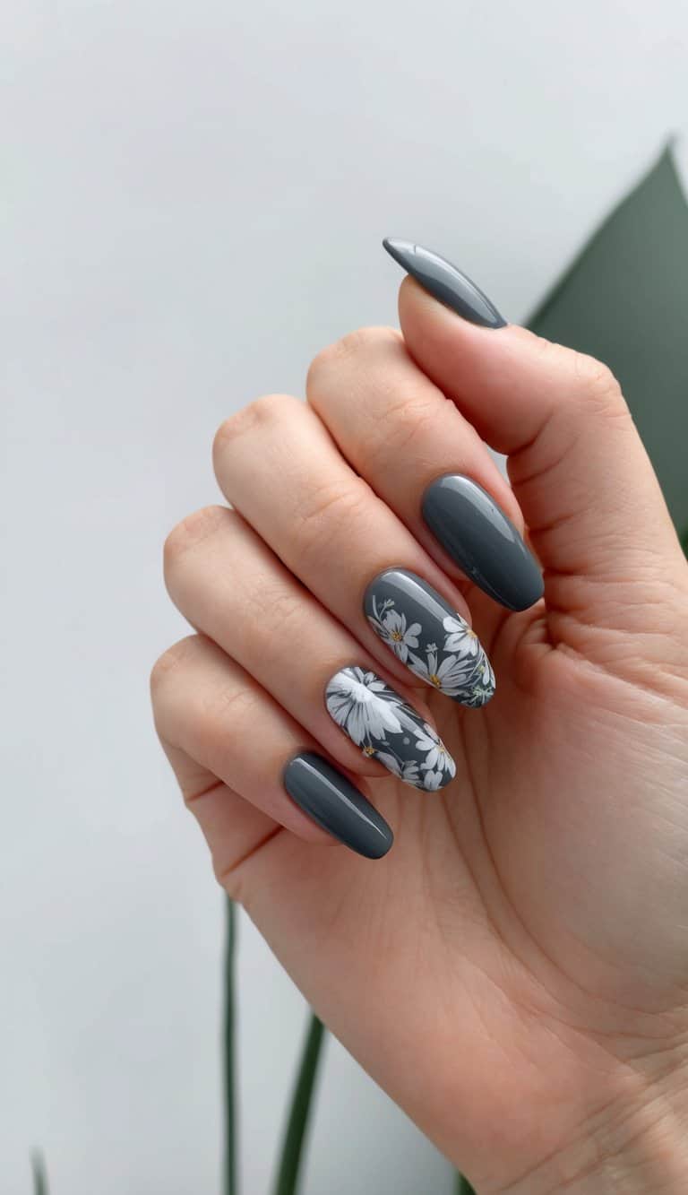A close-up of charcoal gray nails with intricate floral accents, set against a minimalist backdrop