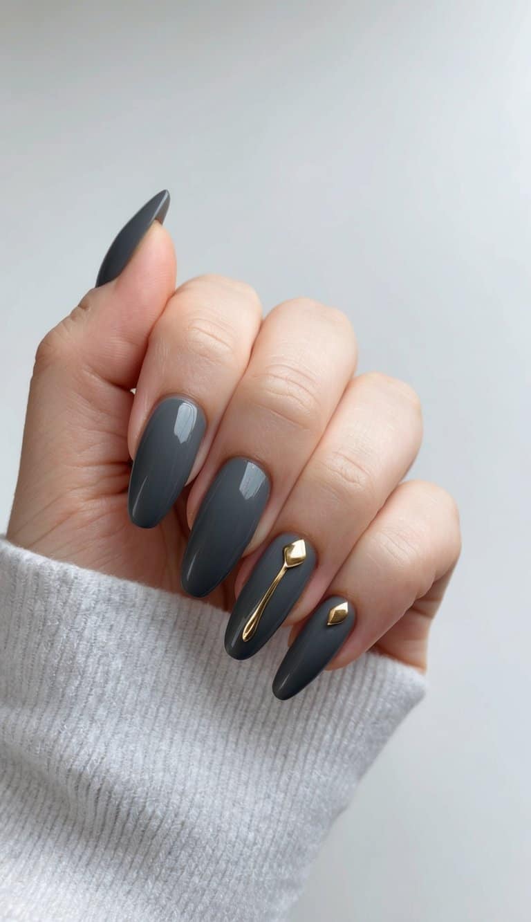 A sleek, charcoal gray nail with minimalist gold accents