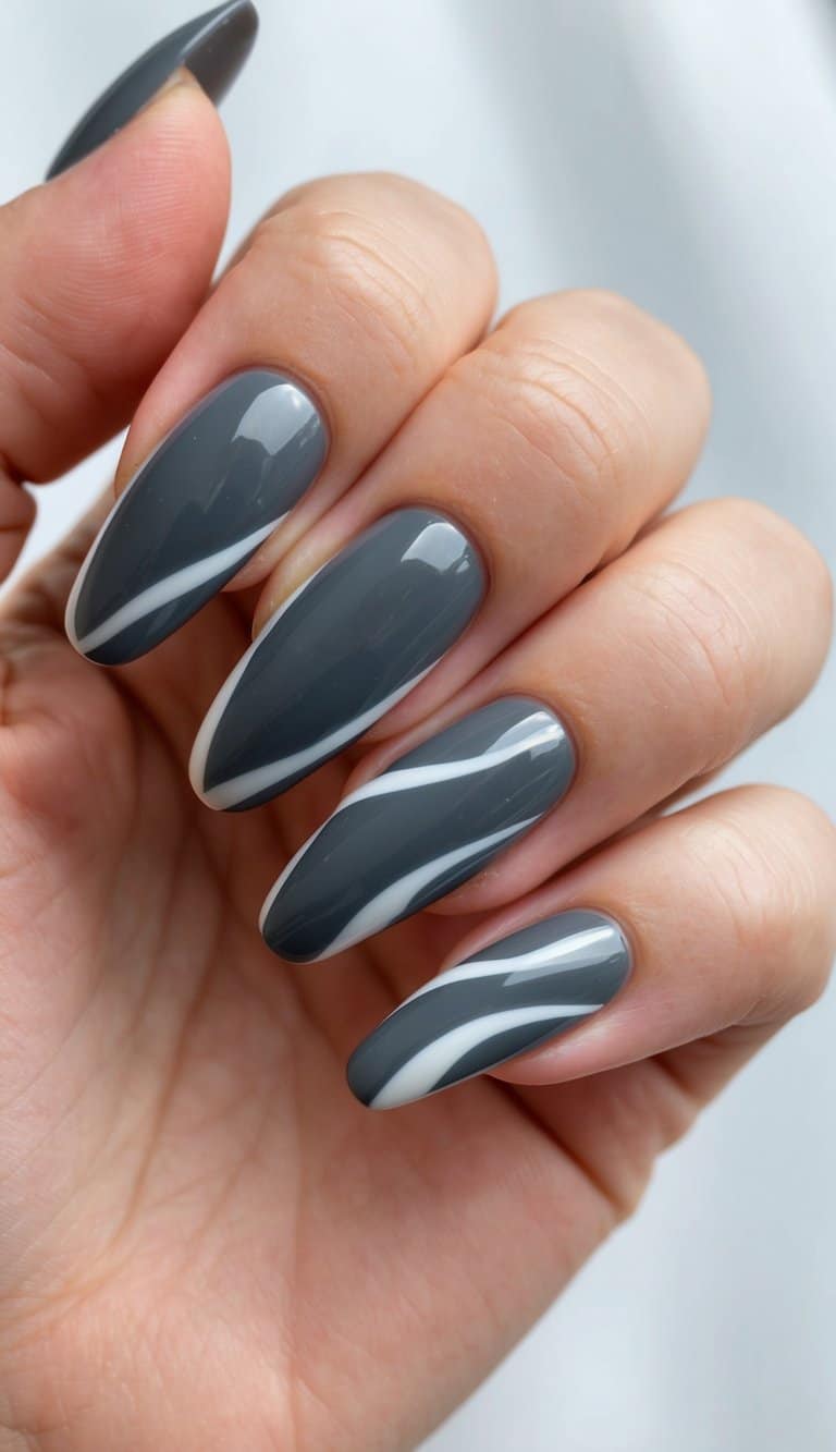 A close-up of charcoal gray nails with artistic wave designs