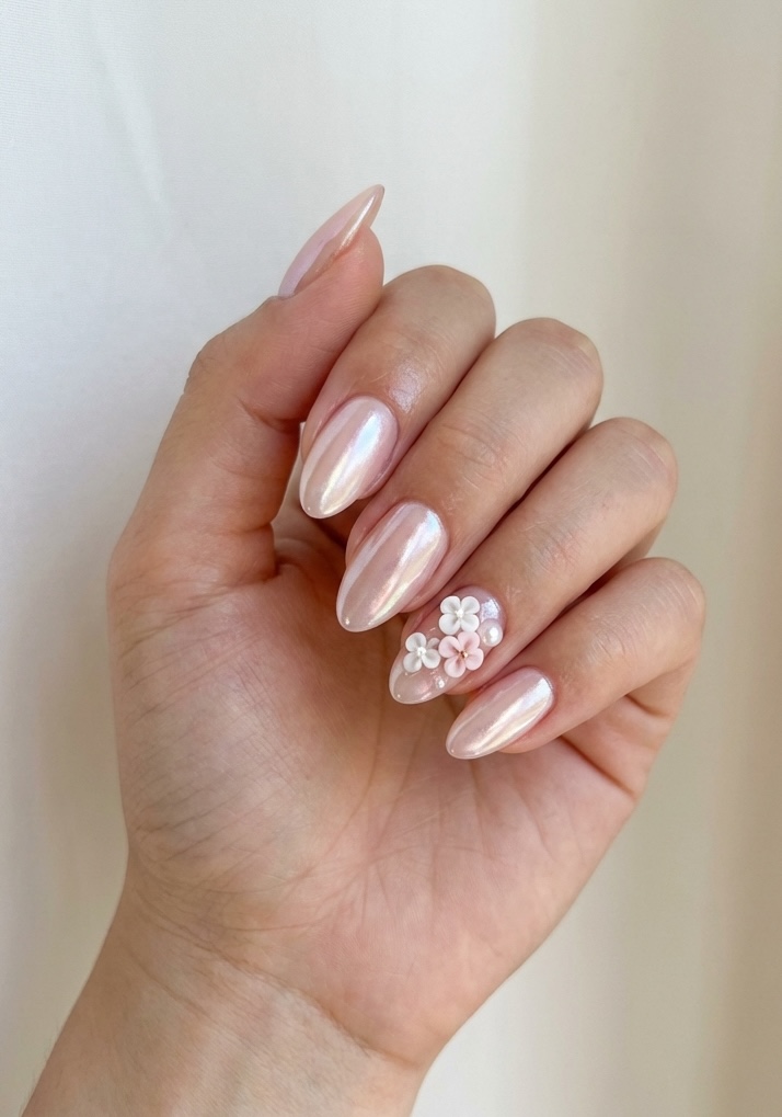 Glossy almond nails with soft pink shimmer and tiny 3D flower designs—an understated prom nail art idea with dreamy details.