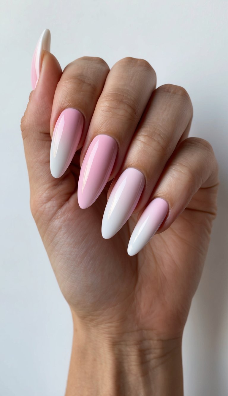 Hand with glossy long nails showcasing alternating halves of pale pink and white polish, illustrating a high-impact pink and white nail art idea
