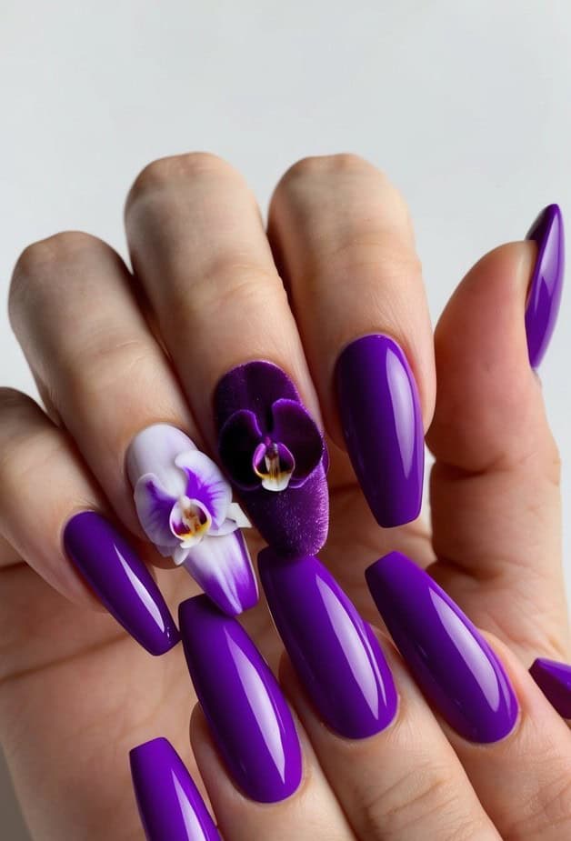 Glossy deep violet nails with tiny, adorable 3D orchid flowers in plush plum and lilac, adding a cute yet elegant floral detail.
