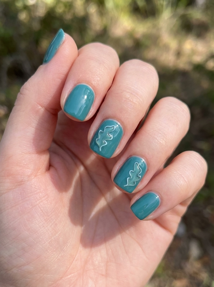 A hand photographed outdoors showing a teal nail art idea with short glossy teal nails, featuring raised white wavy line designs on two accent nails.