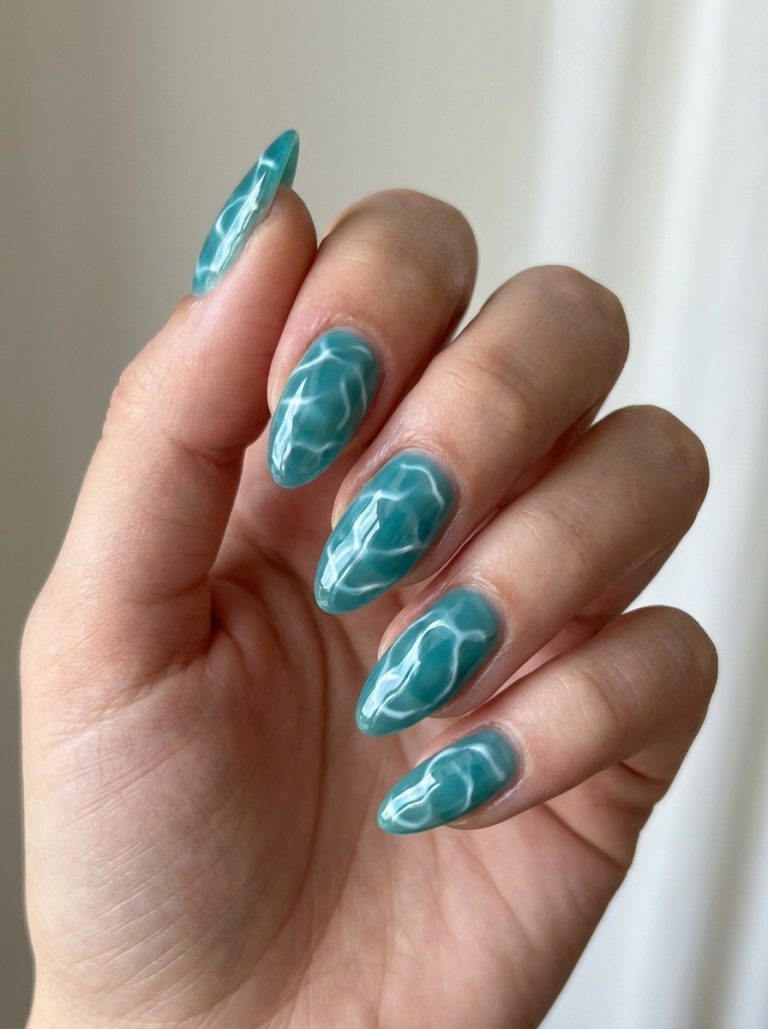 A hand with long nails painted in a glossy blue-green polish, featuring a unique wavy pattern resembling water ripples.