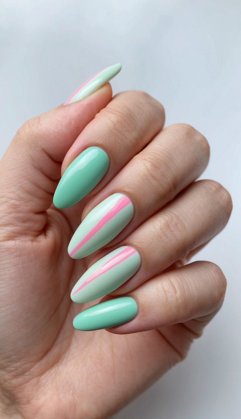 An angled hand pose features a mint green nail art idea with glossy almond nails, showing pastel green tones intersected by a delicate pink stripe.