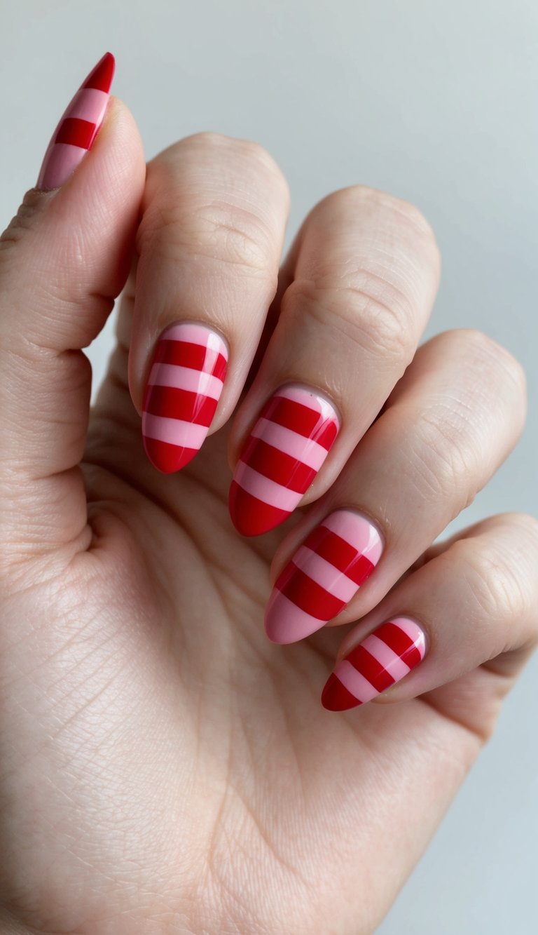 Fingers gently curled against a neutral background, highlighting glossy almond nails with red and pink striped patterns, styled as fun valentine's nail art ideas.