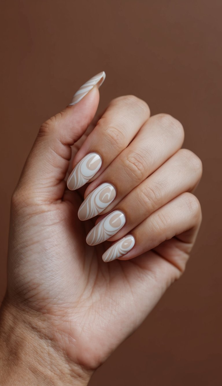 Hand posed against a warm brown backdrop showing almond nails painted in a neutral nail art idea with beige polish and flowing ivory ripple designs.