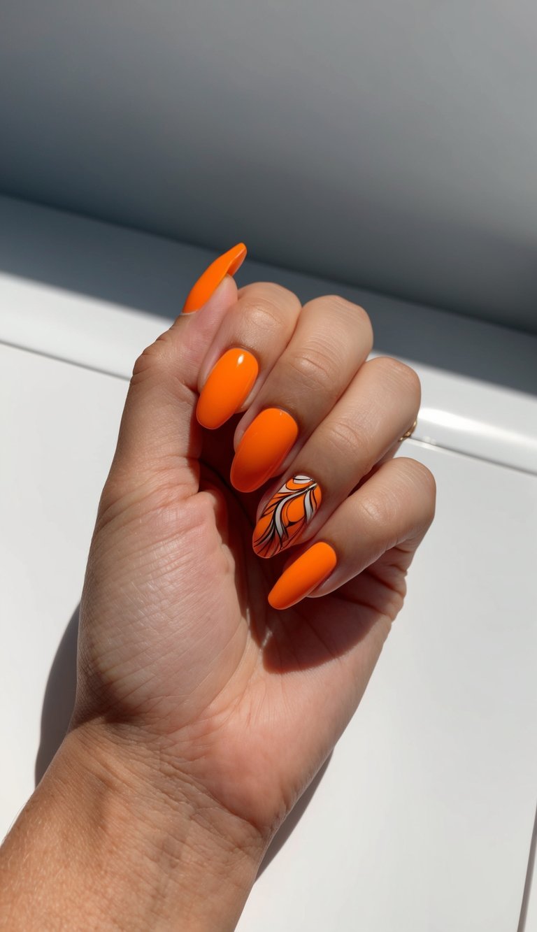 Hand posed near a white surface highlighting an orange nail art idea with glossy orange almond nails and a decorative accent nail with black and white flowing line design.