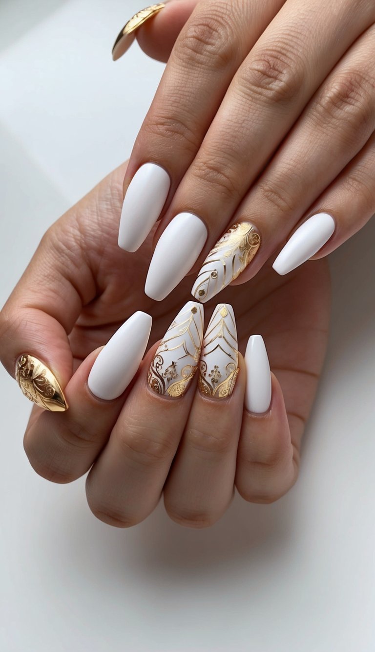 Manicured hands positioned together featuring a white and gold nail art idea with matte ivory coffin nails decorated with ornate gold patterns, raised metallic accents, and intricate filigree designs.