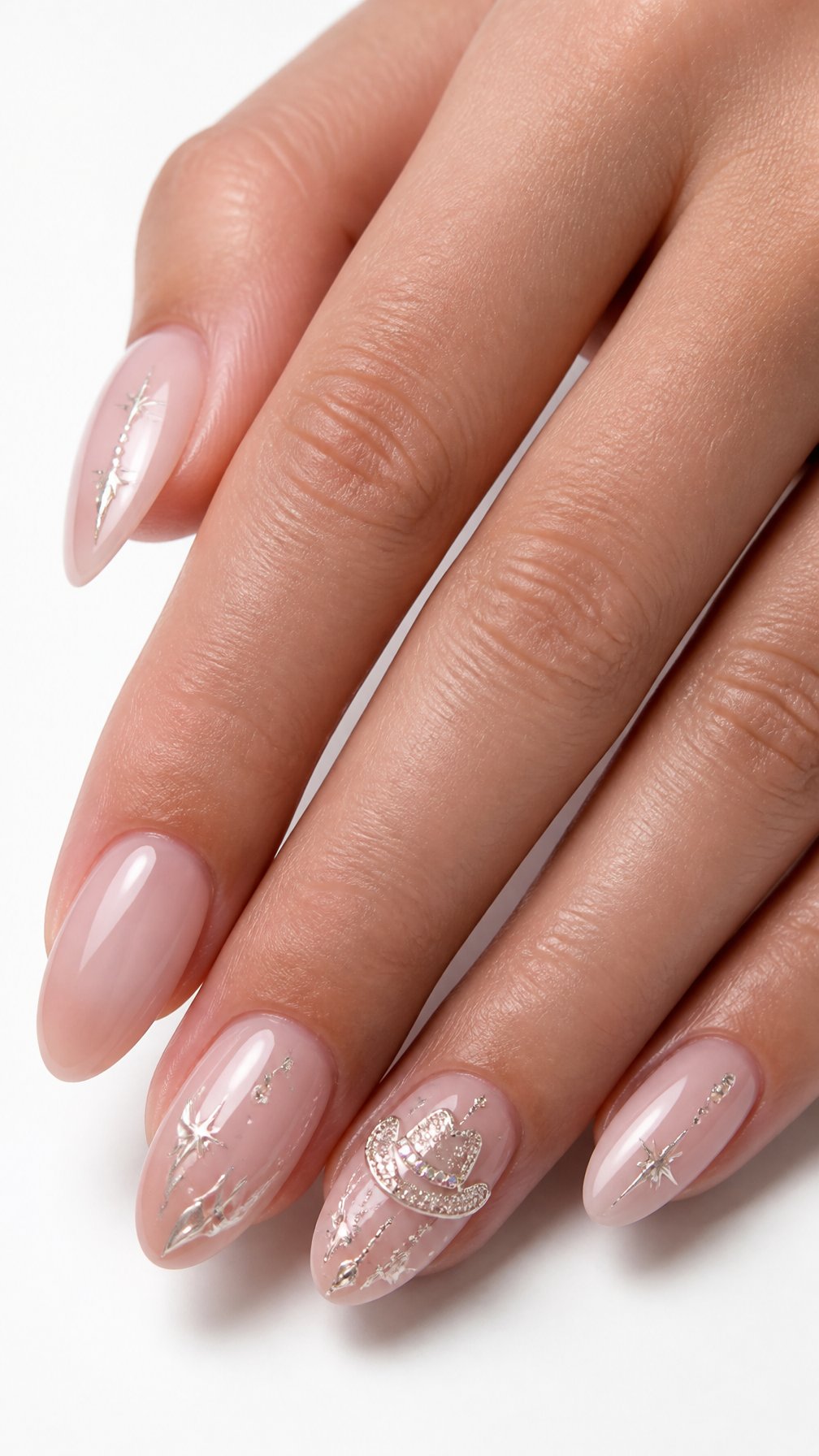 A single hand displays glossy nude manicured nails, including one accent nail decorated with a sparkling rhinestone cowboy hat.