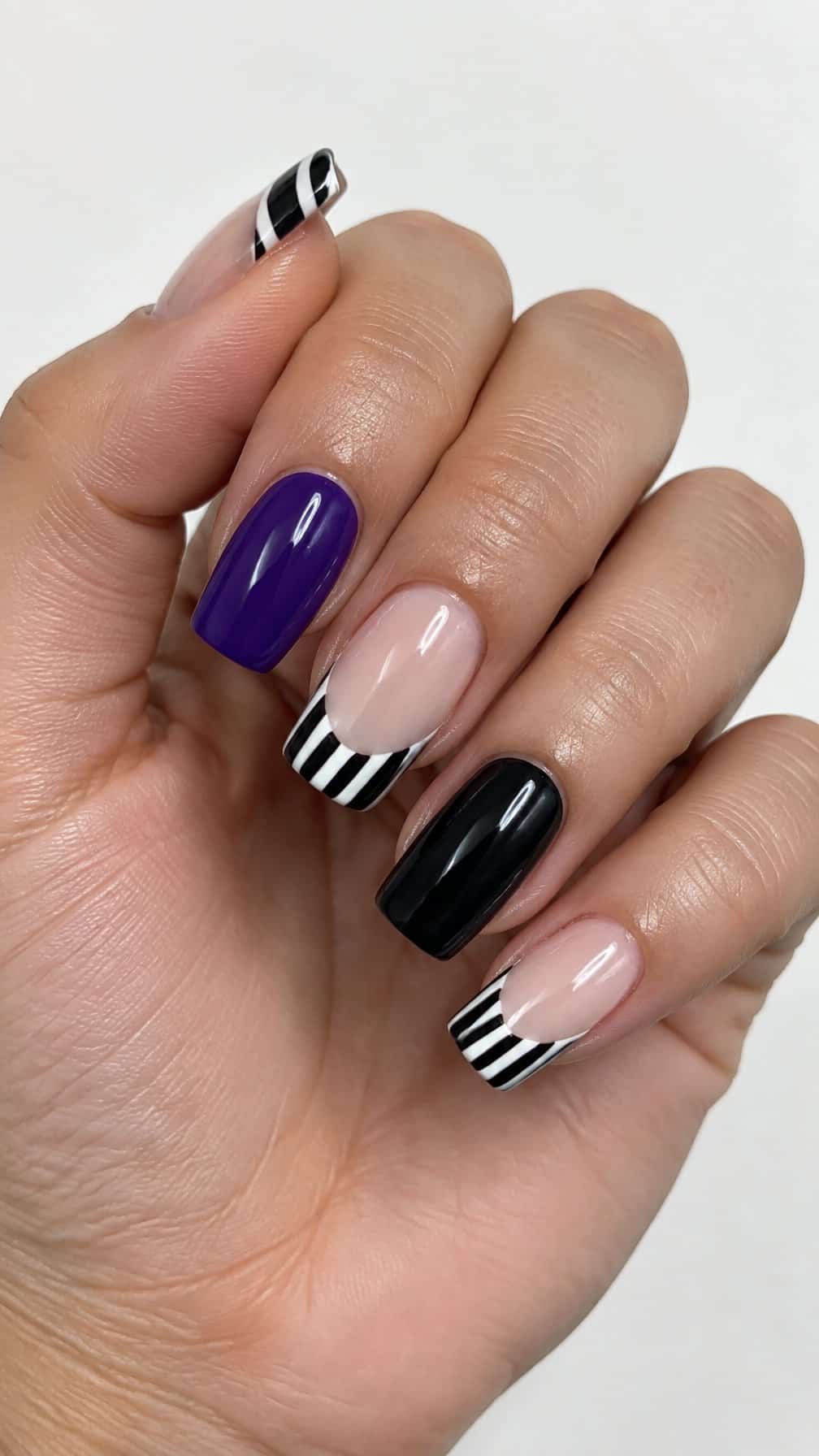 Glossy black, white, and purple striped French tip nails