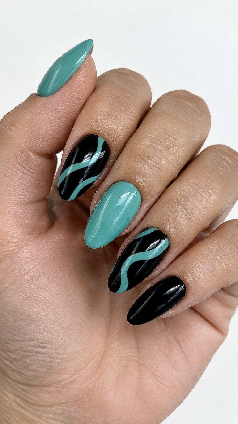 Glossy black and teal almond-shaped nails featuring simple teal wave designs