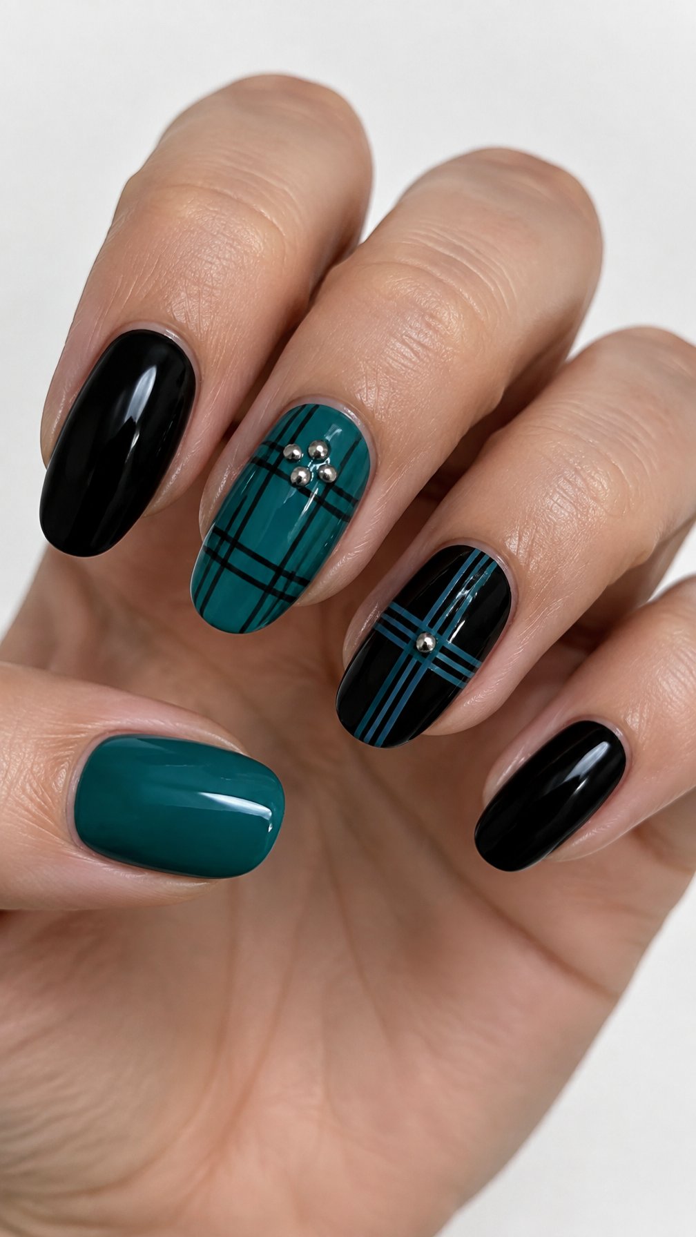 Glossy black and teal plaid gel nails and small metallic accents