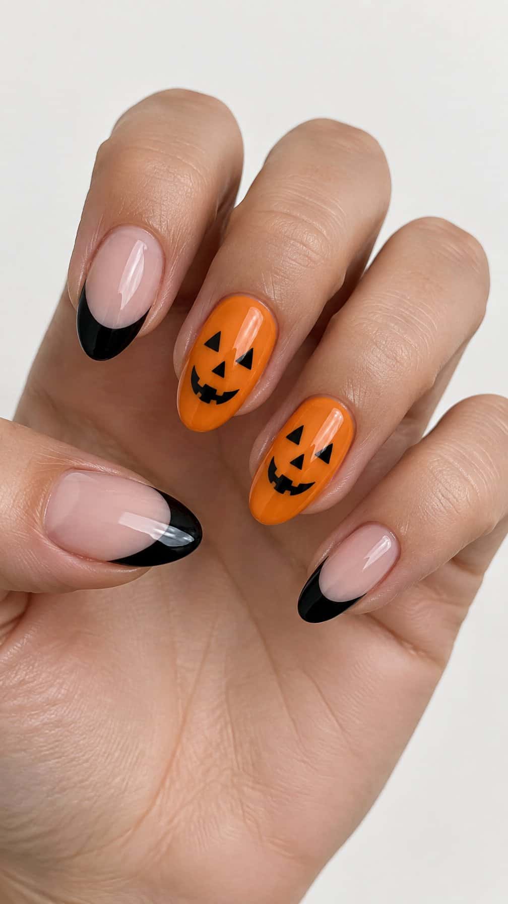 Glossy black French tip nails and pumpkin-face accent nails