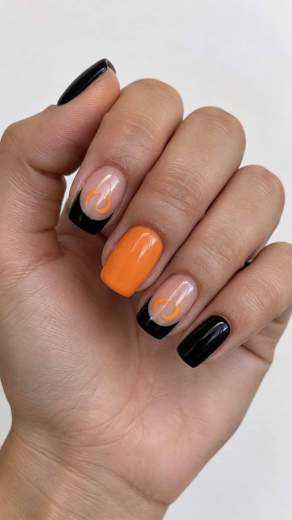 Glossy black and orange crescent-moon French tip nails