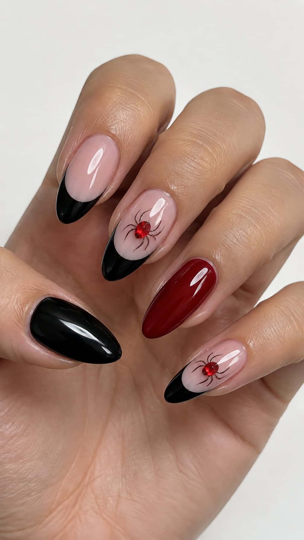 Glossy black French-tip nails and red spider accents