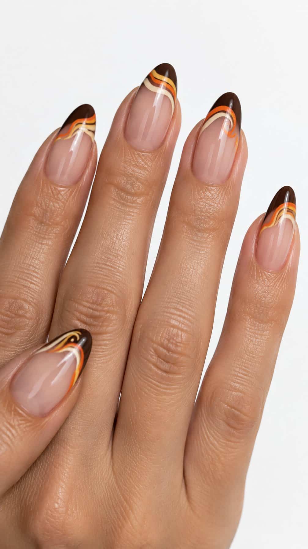 Glossy brown French tip nails with orange, ivory, and yellow candy-corn swirl accents
