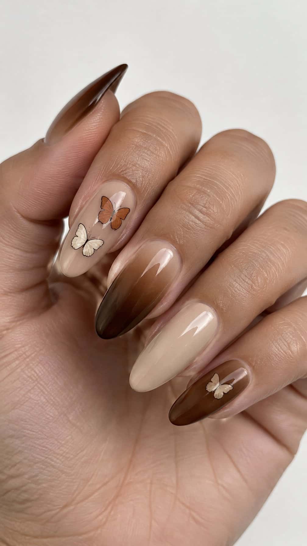 Glossy brown ombre nails with small butterfly designs