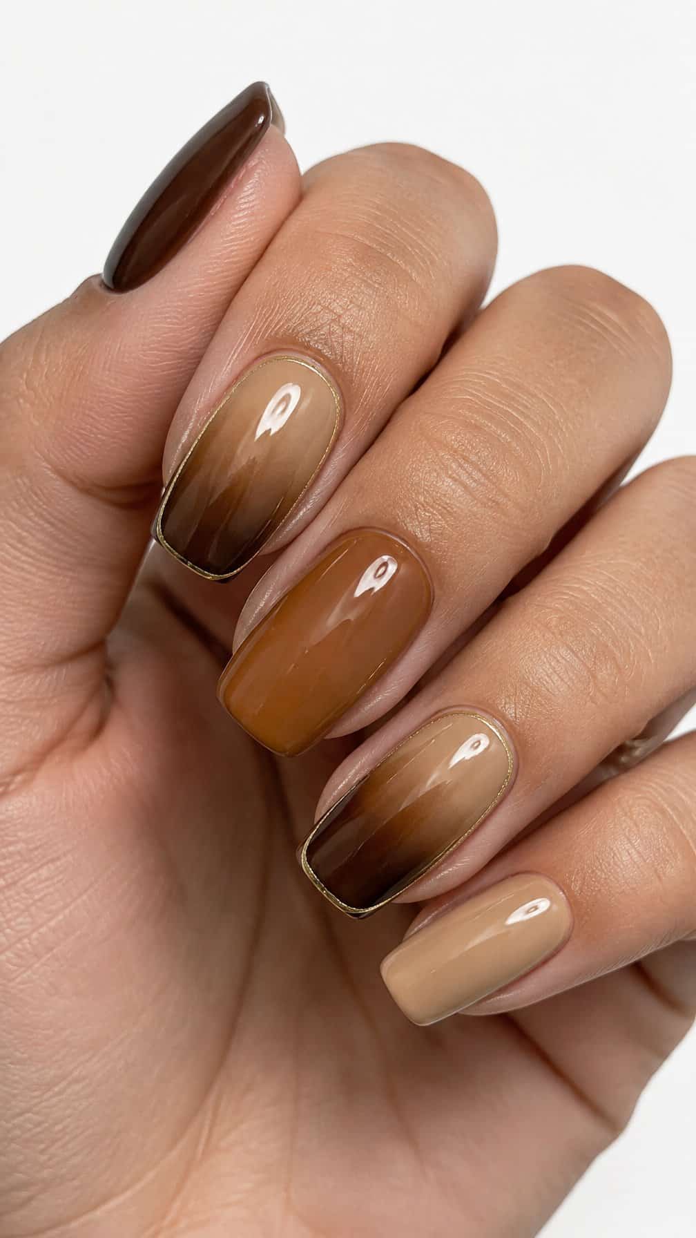 Glossy brown ombre nails accented by fine gold outlines