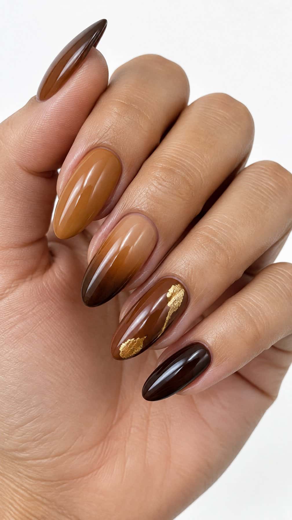 Glossy brown ombre nails and small gold accents
