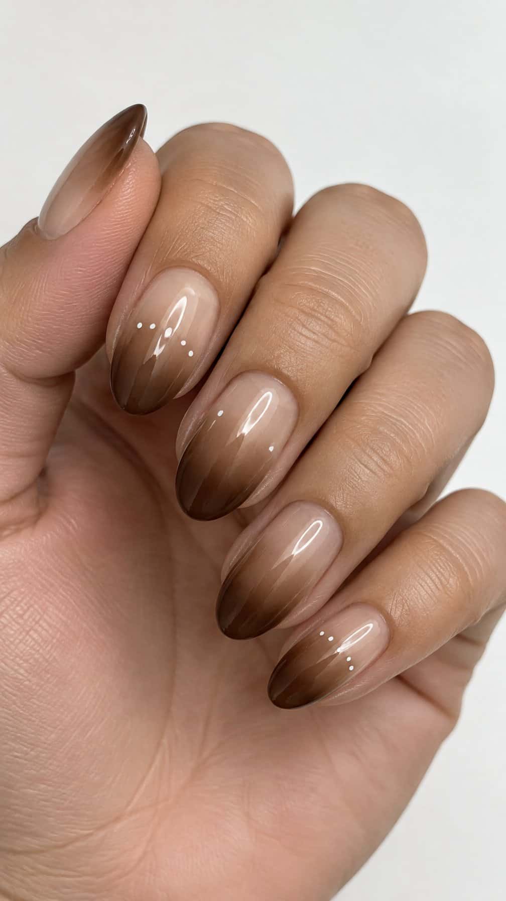Glossy brown ombré nails decorated with small white dots