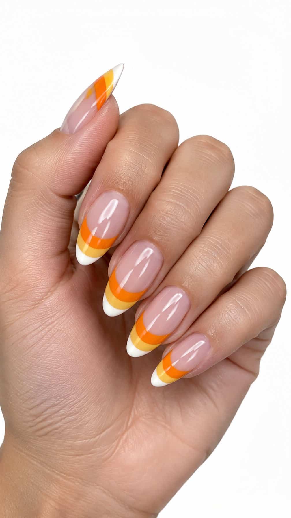 Glossy almond-shaped nails featuring white, orange, and yellow candy corn French tips