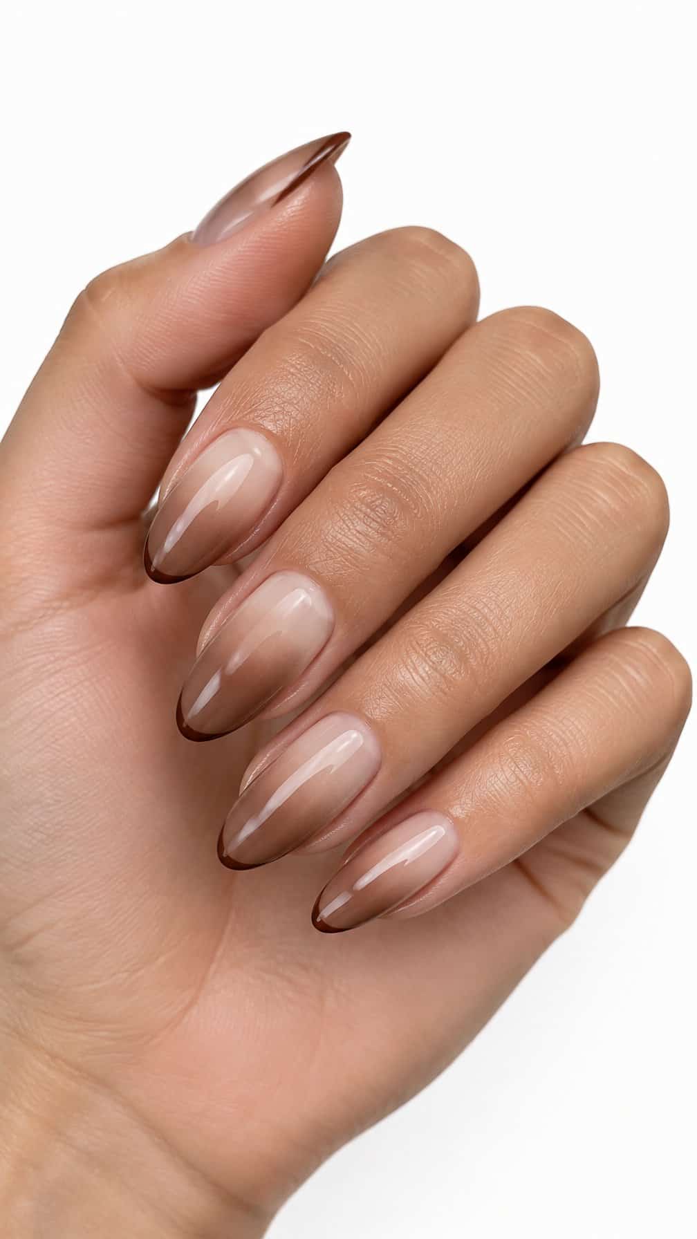 Five glossy almond-shaped nails with creamy beige to coffee-brown ombré polish and thin brown French tips