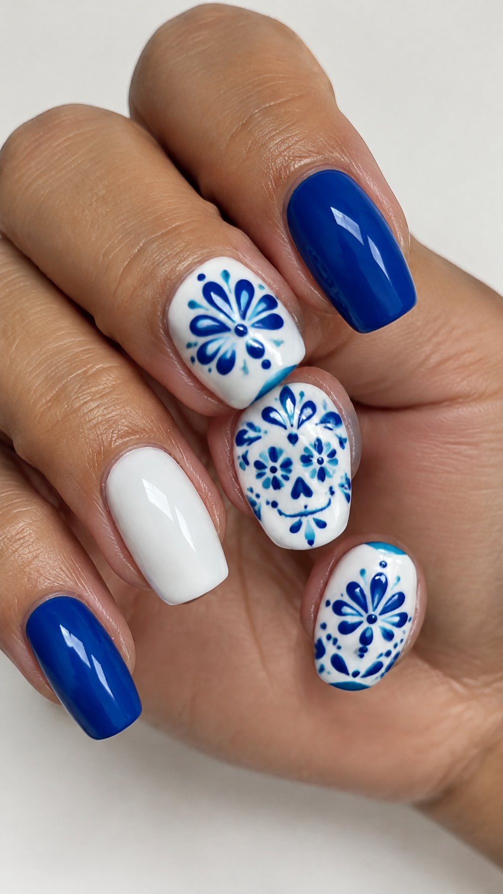 Glossy blue-and-white patterned gel nails rests