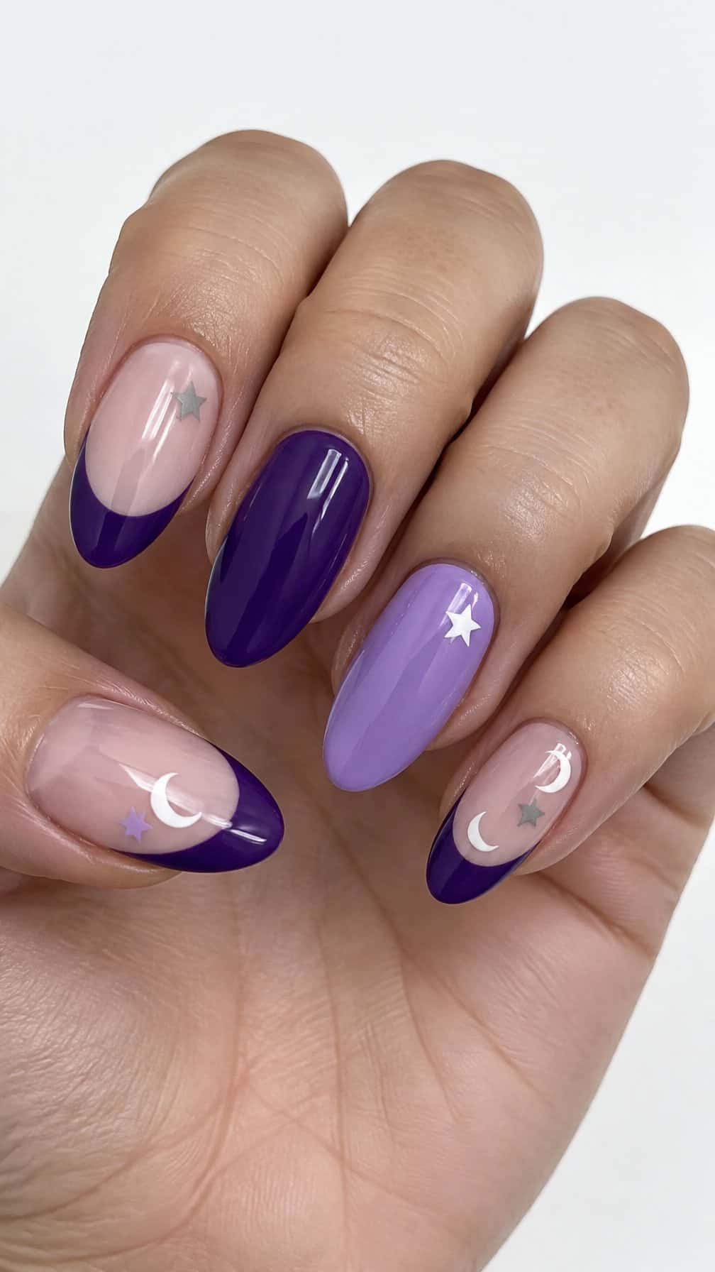 Glossy purple French-tip nails decorated with small moons and stars