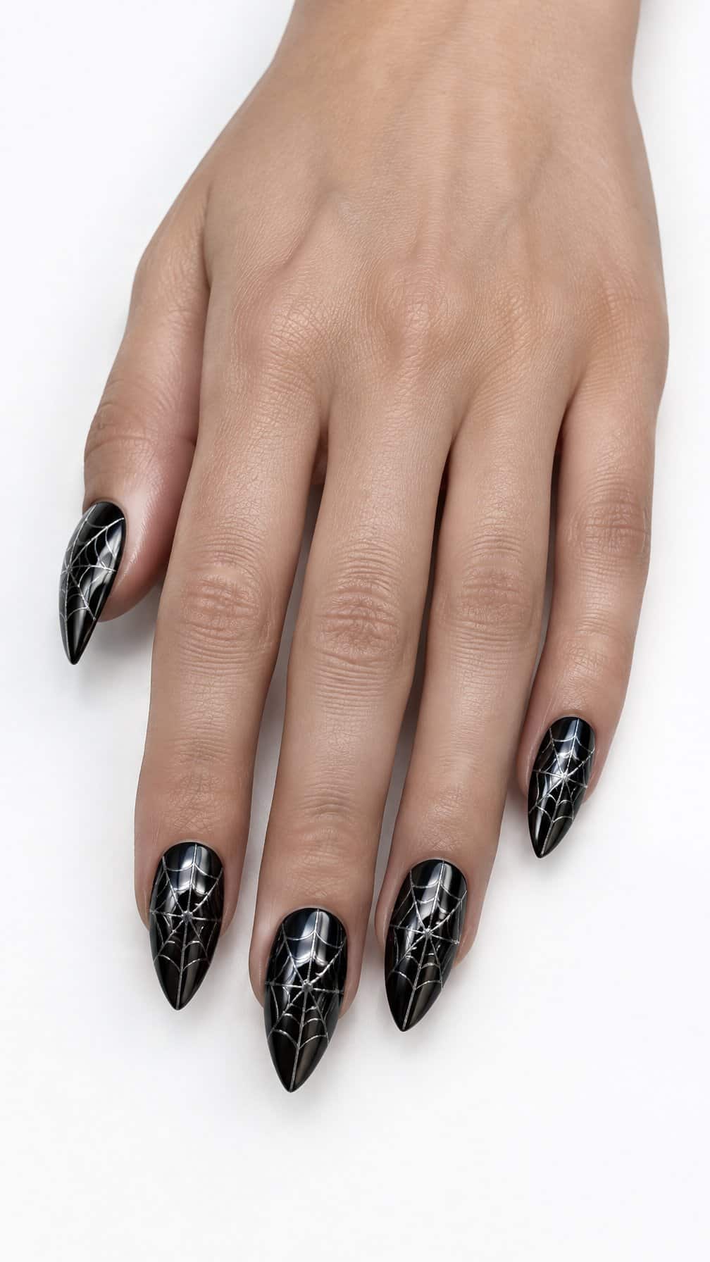 Glossy black chrome nails decorated with silver spider-web designs rests