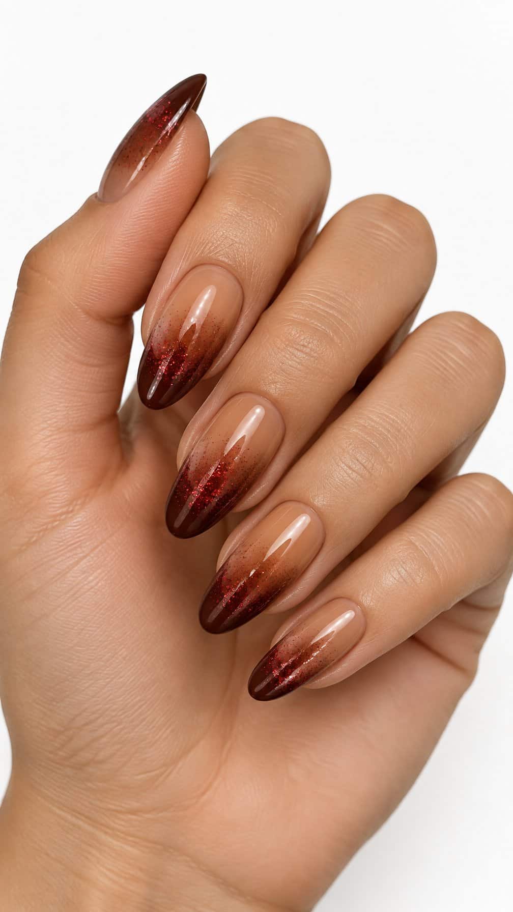 Glossy cinnamon-brown ombre nails decorated with red glitter