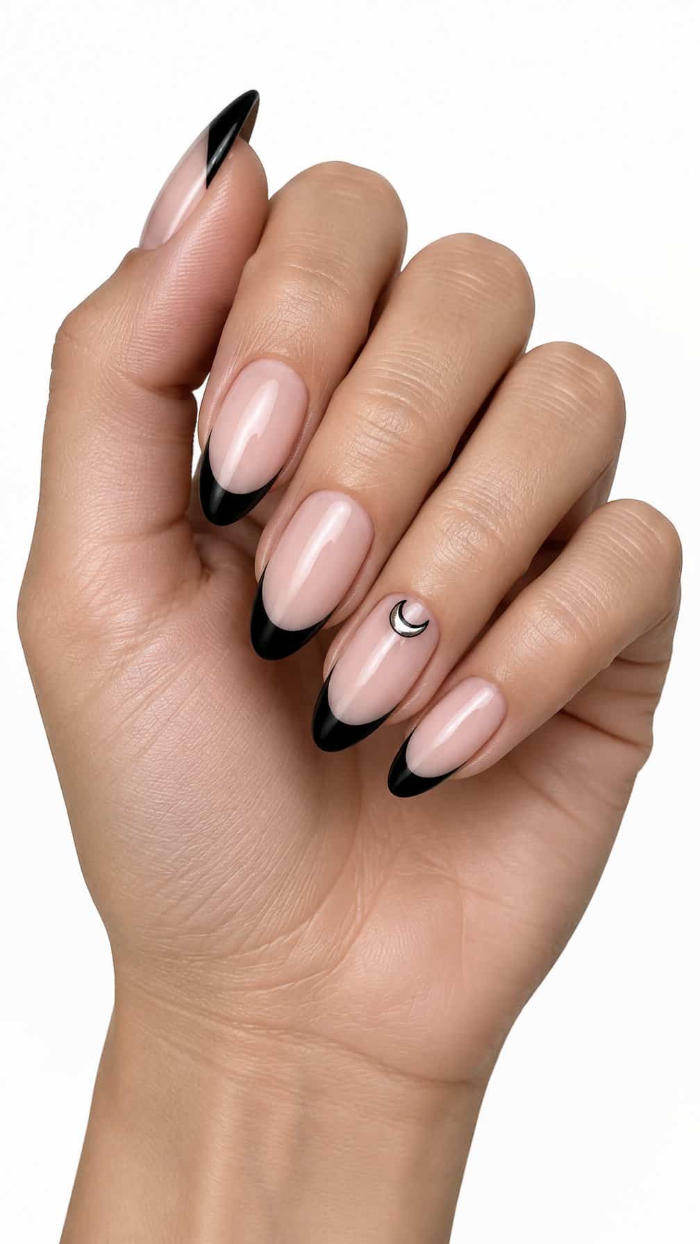 Glossy nude nails, black French tips, and a small crescent moon accent on one nail