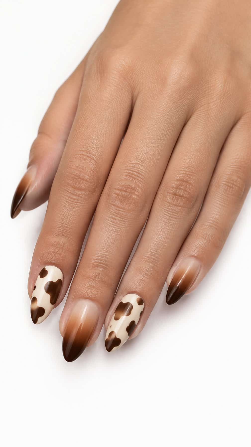Glossy brown ombre nails and cream cow-print accent nails