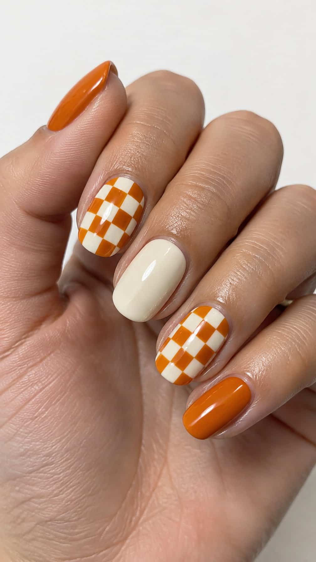 Glossy cream and pumpkin orange checkerboard manicure