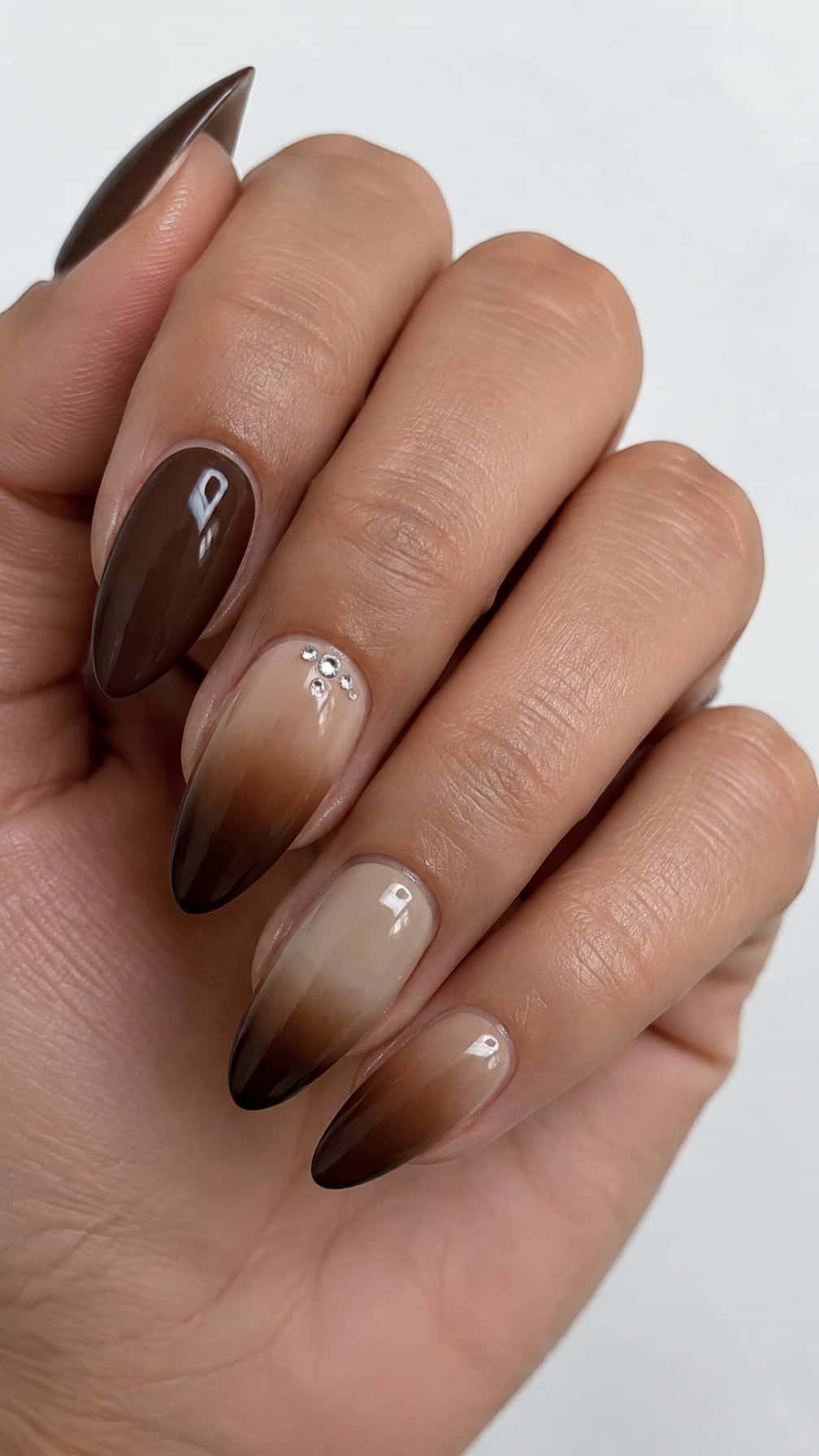 Glossy brown ombre nails and a few tiny rhinestone accents
