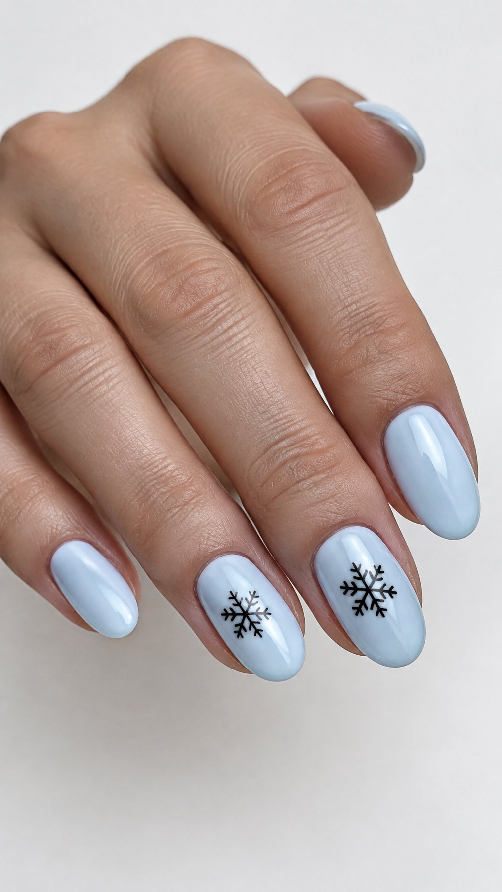 Glossy icy blue nails and black snowflake designs