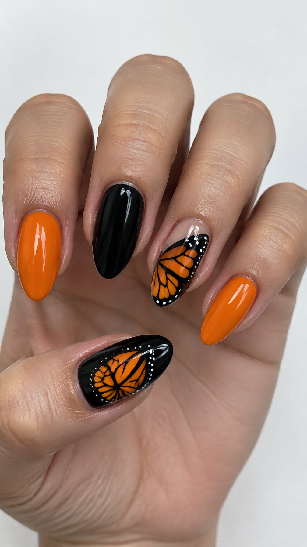 Glossy black and orange butterfly-themed manicure