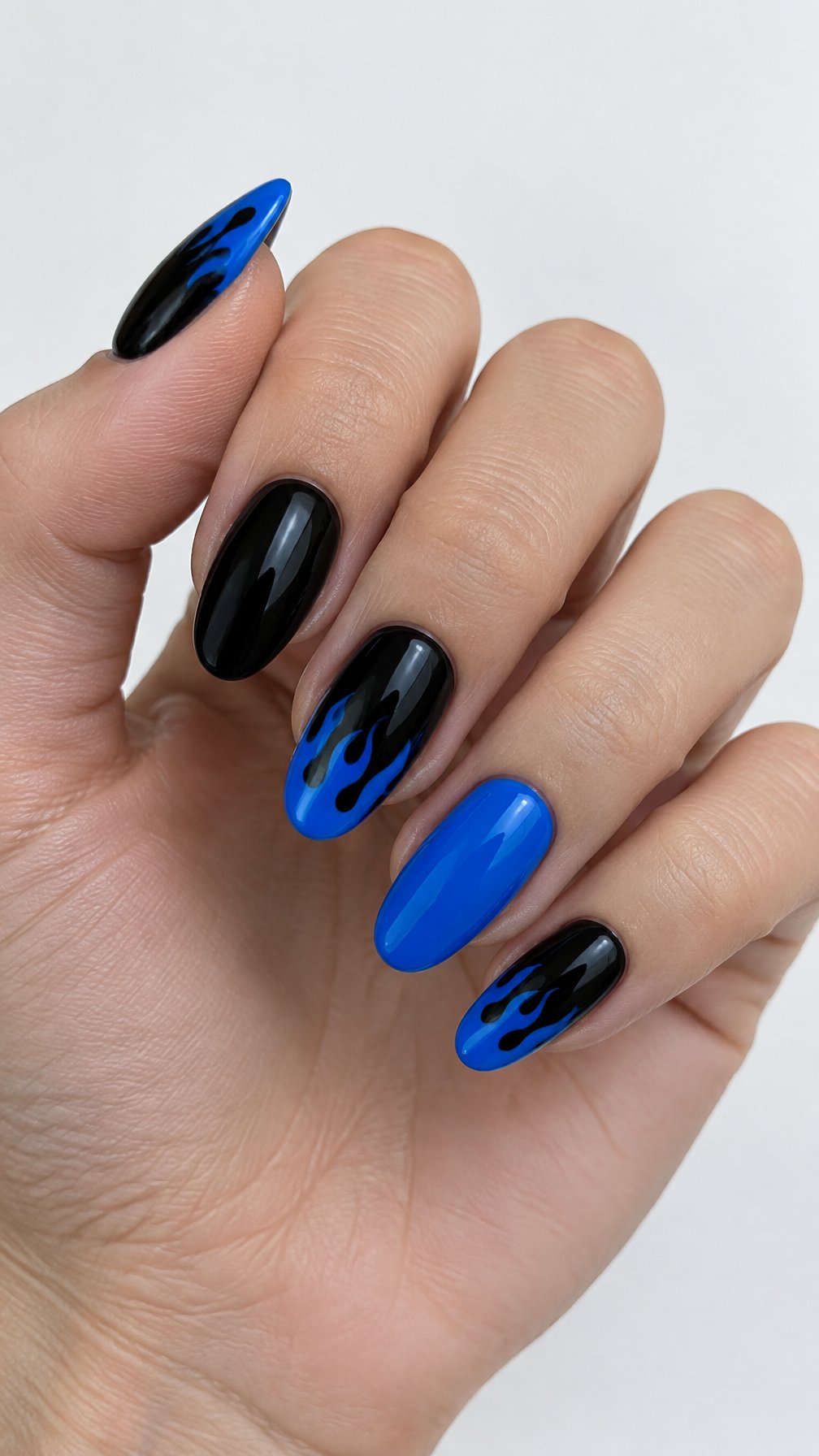 Glossy black nails decorated with bright blue flame tips rests