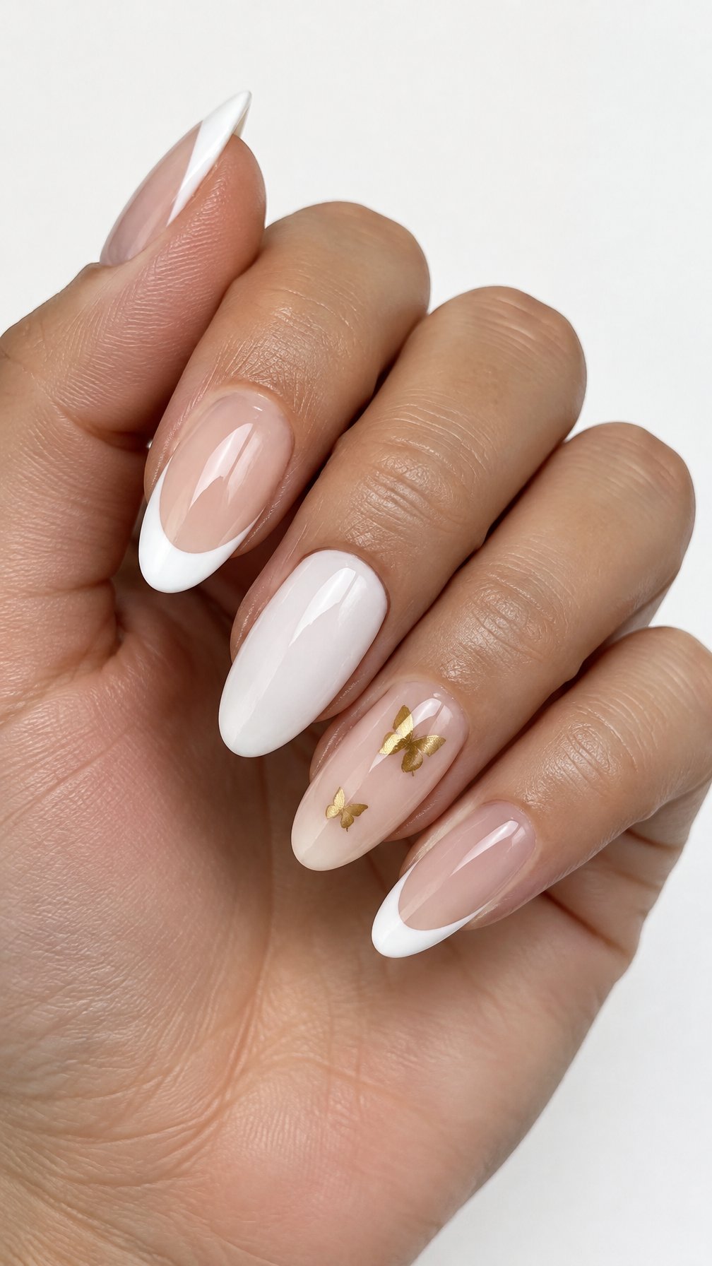 Glossy white French-tip nails and small gold butterfly accents