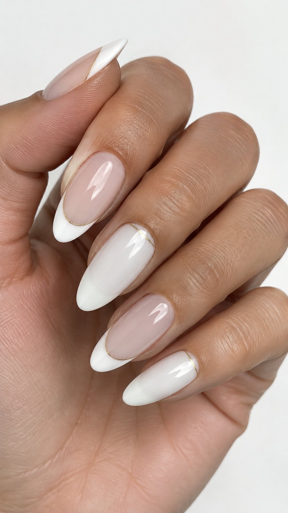 Glossy milky white French-tip nails edged with thin gold lines