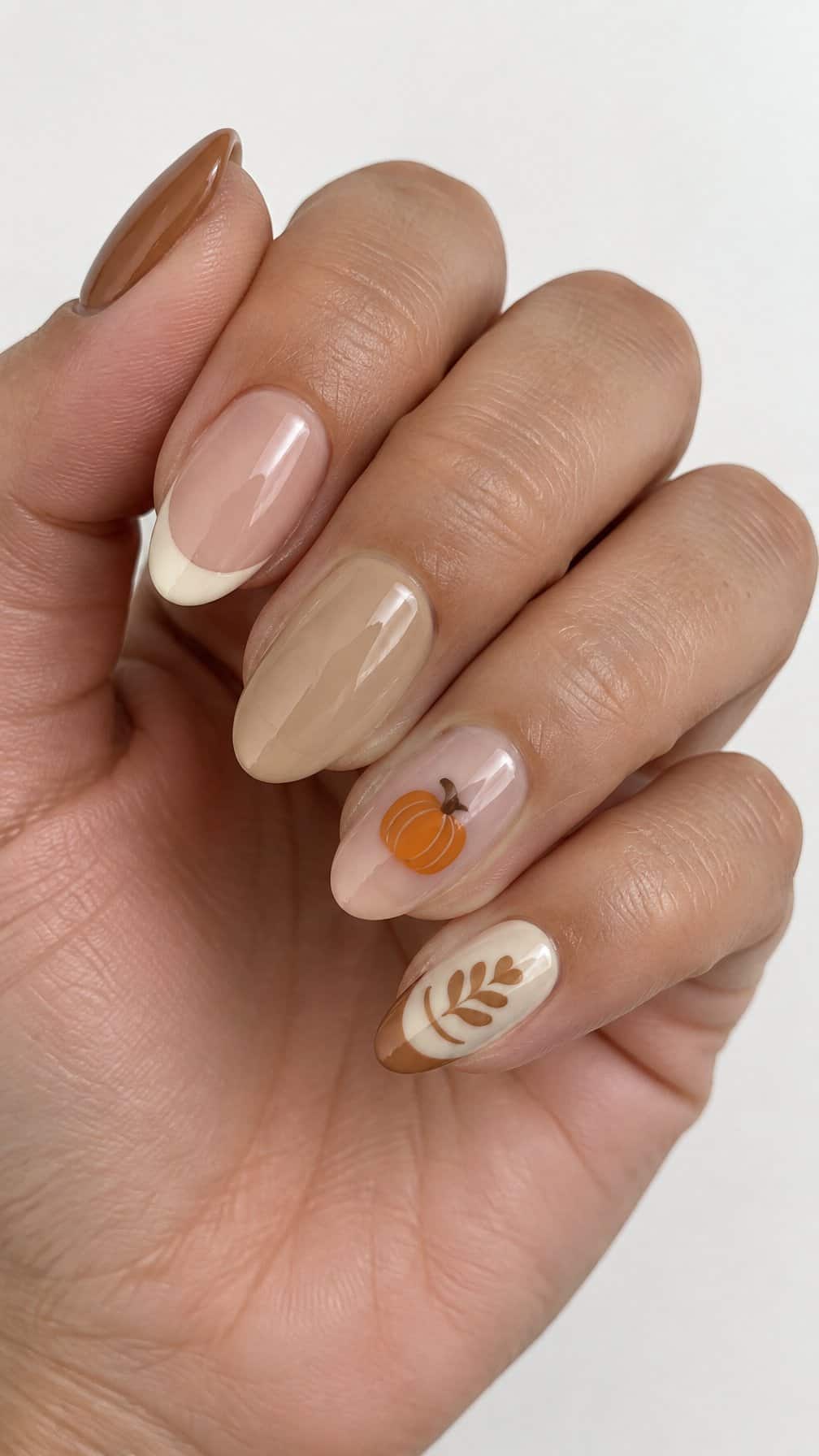 Glossy cream, caramel, and pumpkin-colored manicure designs