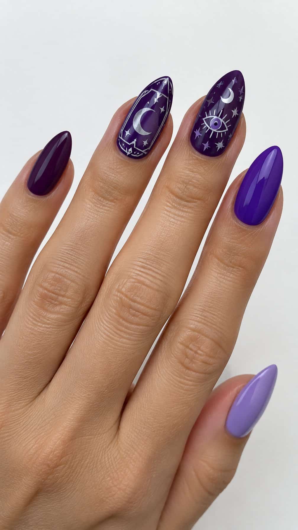 Glossy purple manicure featuring solid nails, moons, stars, and a simple eye design