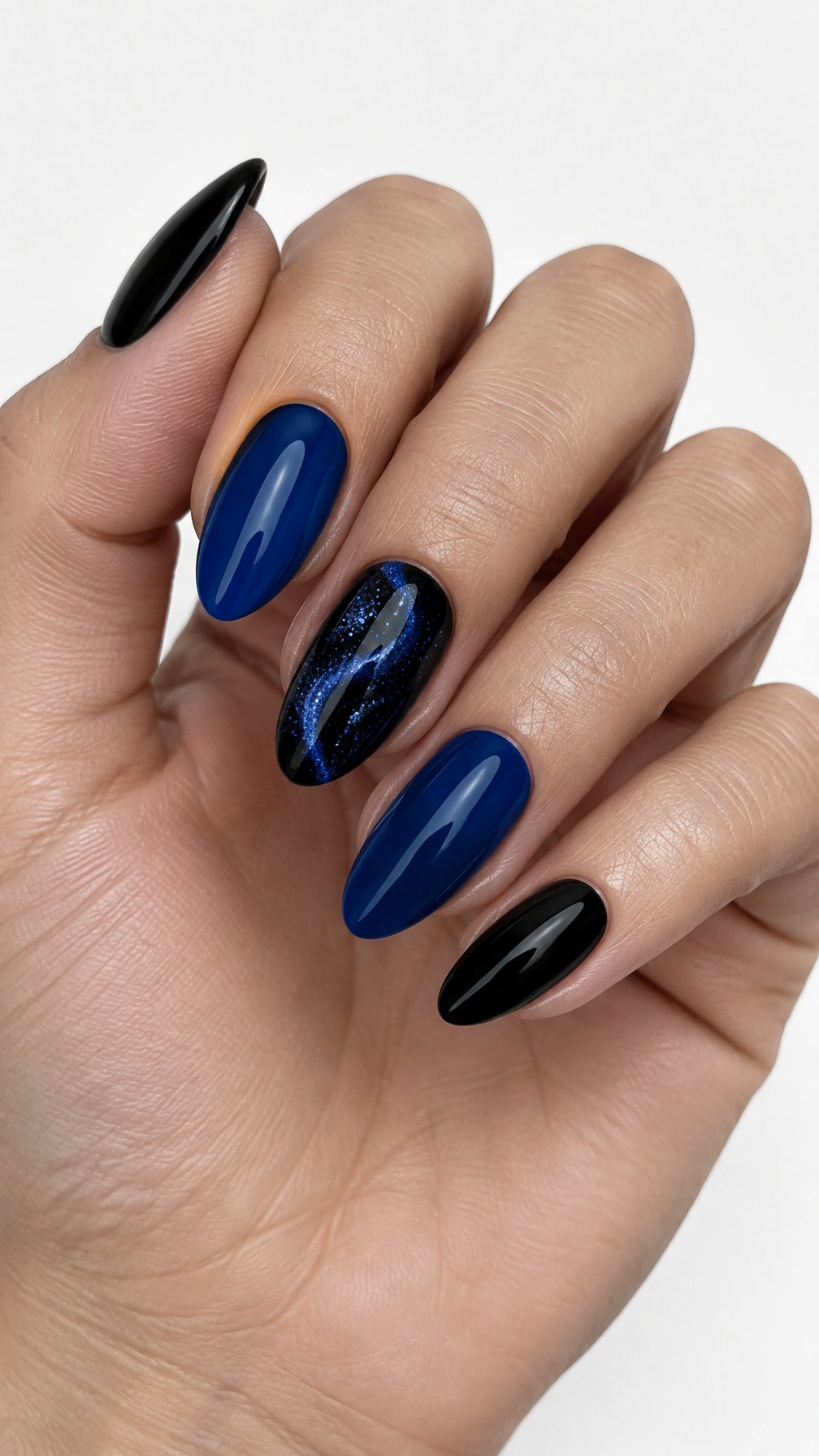 A glossy black and sapphire blue manicure with glitter accents