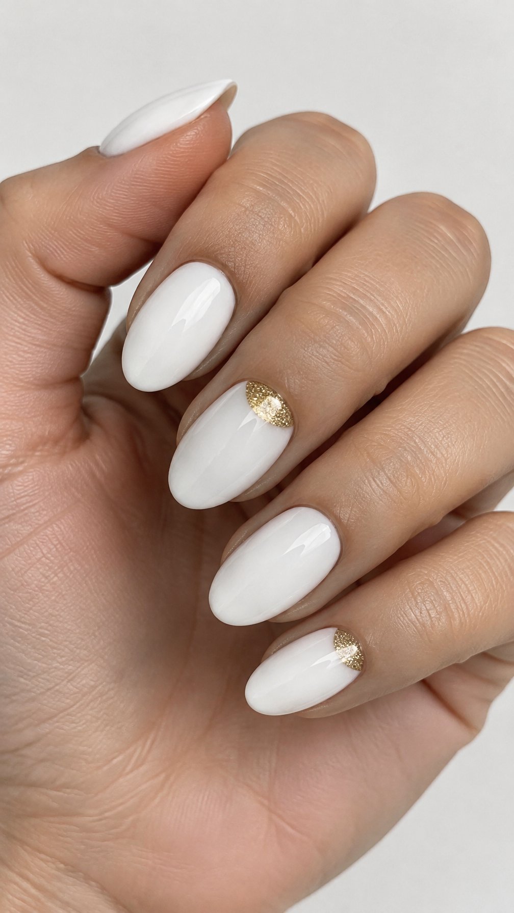 Glossy white and gold half-moon manicure