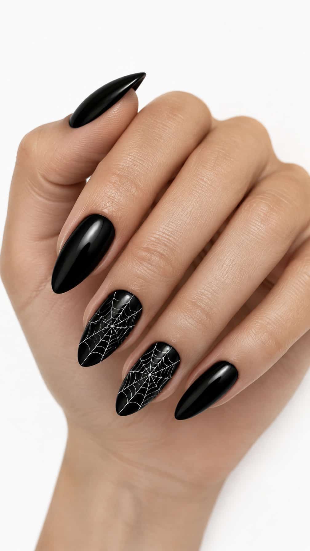 Glossy black almond-shaped nails, including white spider web designs on two nails, rests