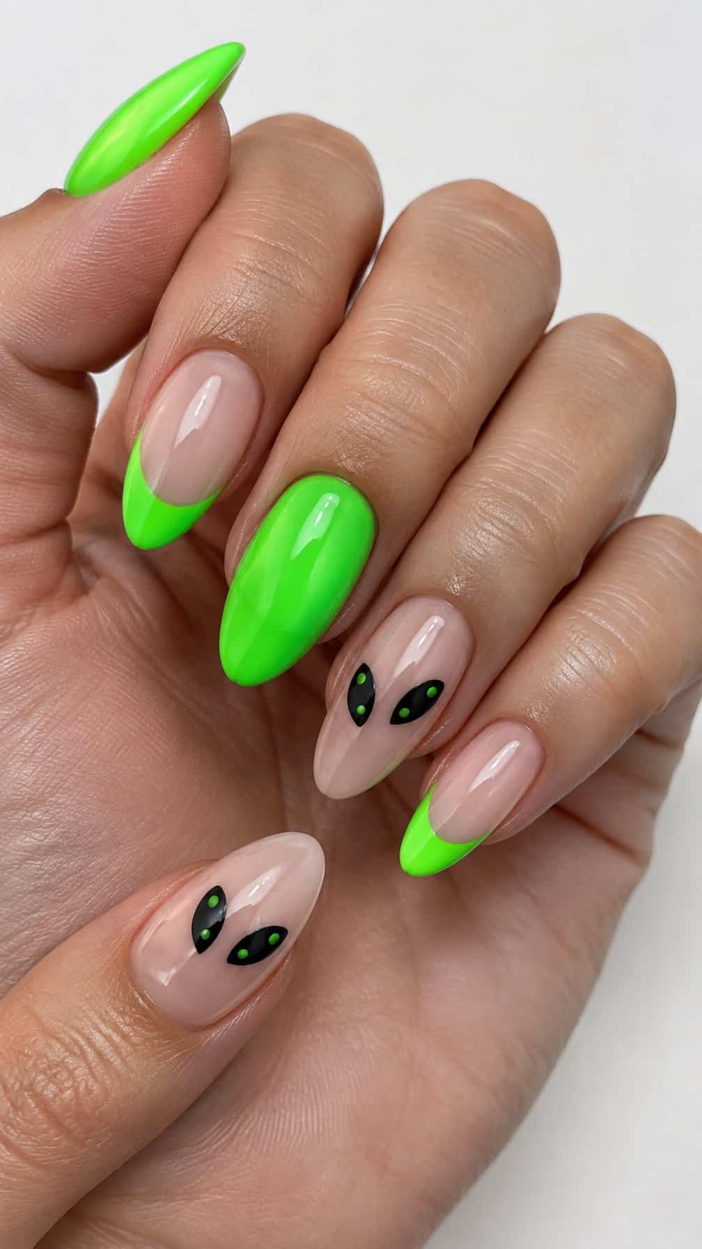 Glossy neon green French-tip nails and black alien-eye designs