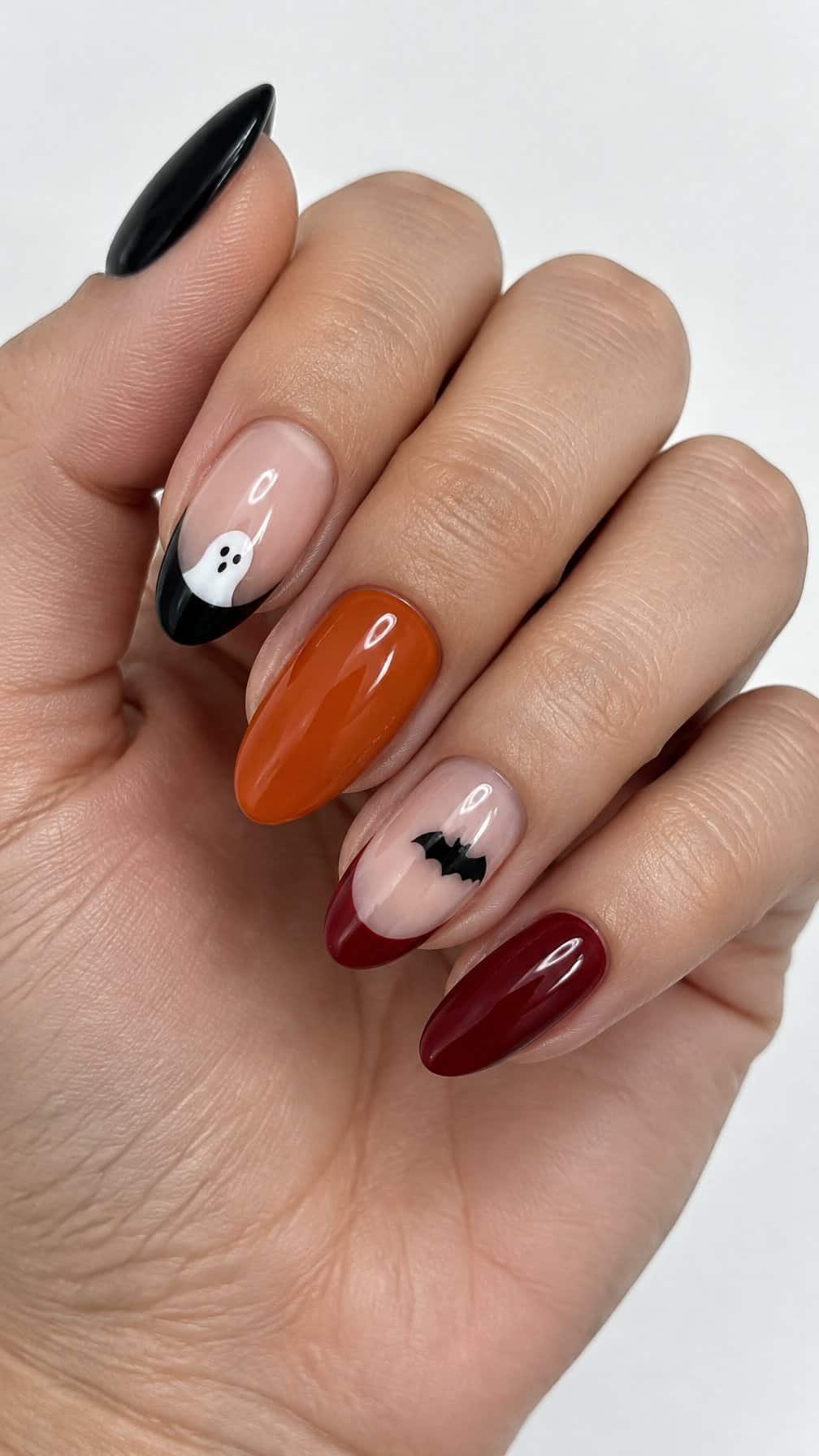 Glossy black, orange, red, and white Halloween-themed nail designs
