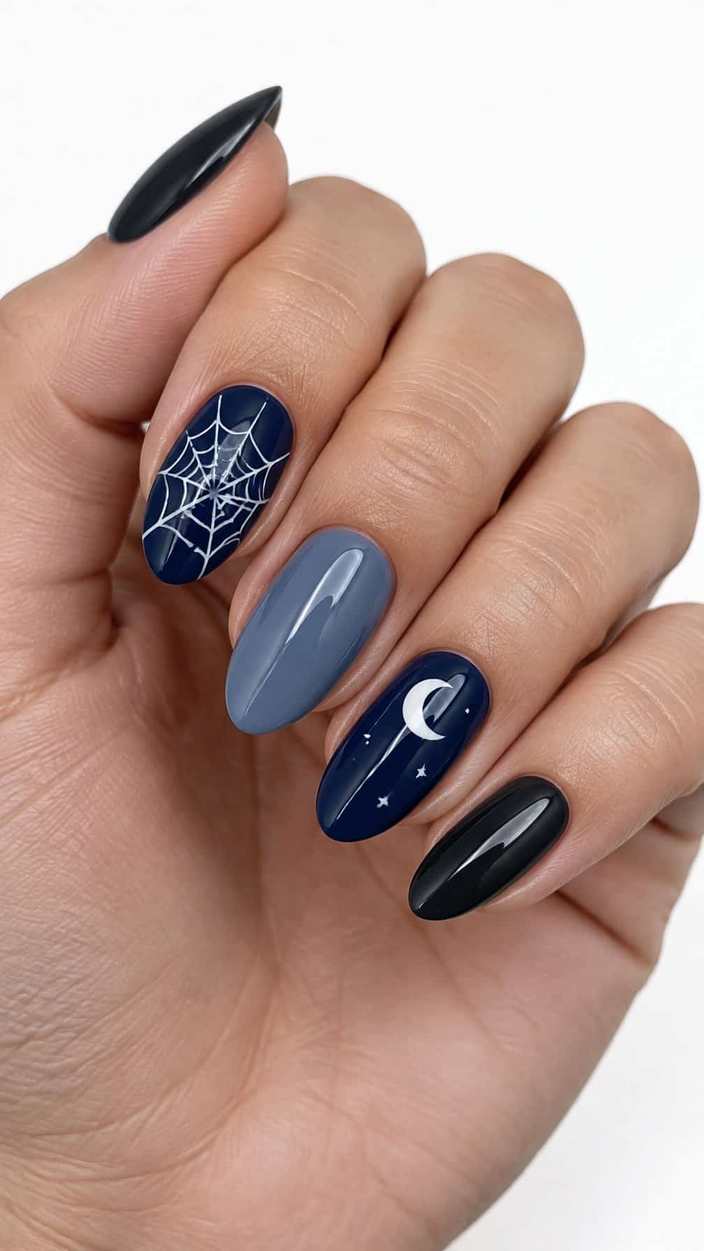 Dark blue and gray manicure nails, including white spider webs and a small crescent moon