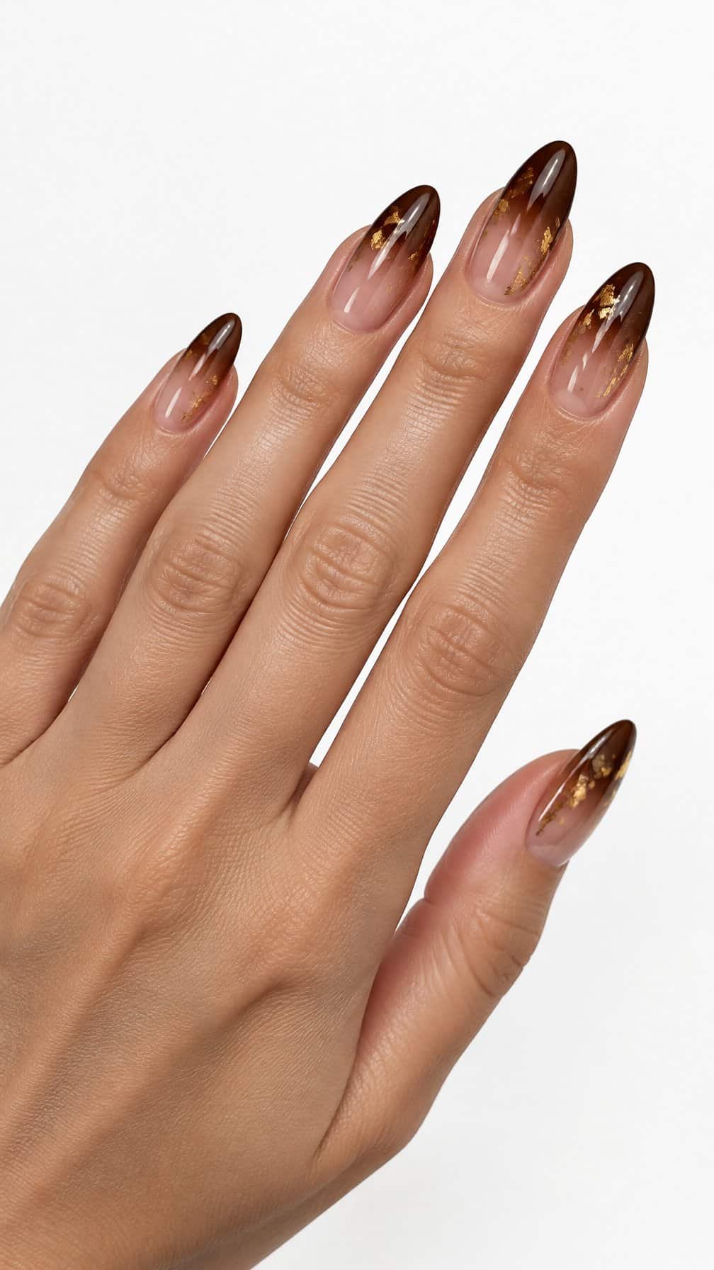 Glossy cocoa brown ombre nails decorated with small gold foil accents